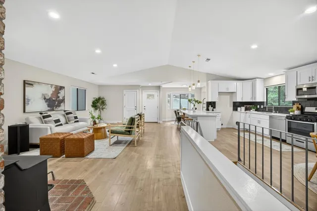 a kitchen with stainless steel appliances kitchen island a table chairs refrigerator and microwave