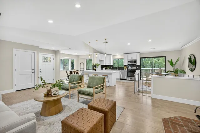 a kitchen with stainless steel appliances a dining table chairs and stove top oven