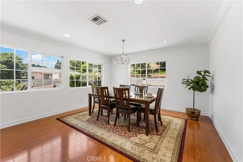 a dining room with furniture a rug and a potted plant