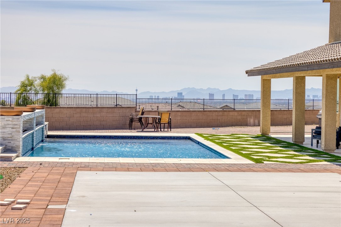 5592 Hickory Tree Street Las Vegas, NV 89149 - Photo 15 of 87 Outdoor pool with a patio area, a mountain view, and a fenced backyard