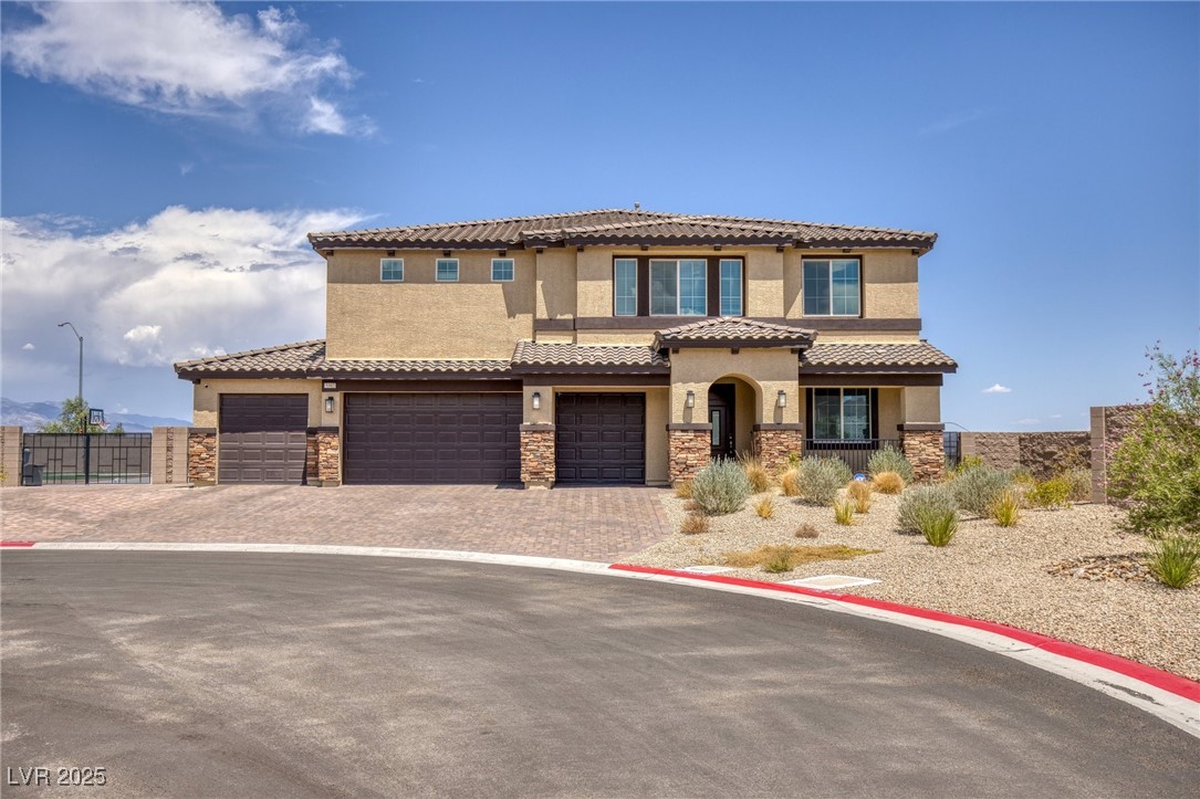 5592 Hickory Tree Street Las Vegas, NV 89149 - Photo 3 of 87 Mediterranean / spanish home featuring stucco siding, decorative driveway, stone siding, a garage, and a tiled roof
