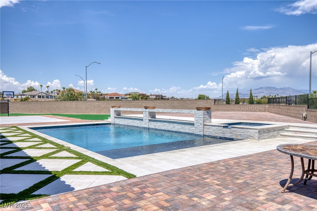 5592 Hickory Tree Street Las Vegas, NV 89149 - Photo 68 of 87 View of pool with a patio area, a fenced backyard, a pool with connected hot tub, and a mountain view