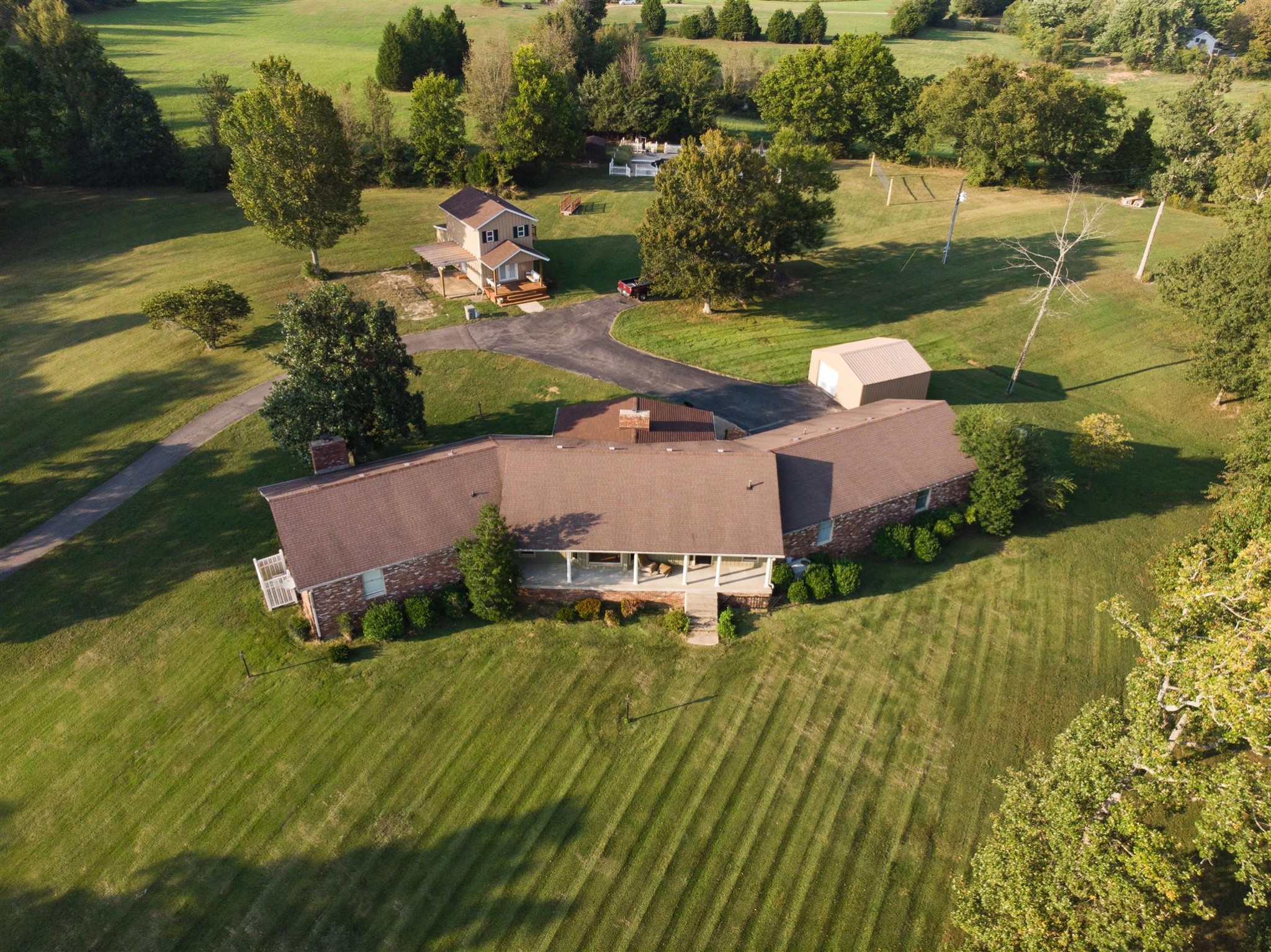 an aerial view of a house with a garden and lake view