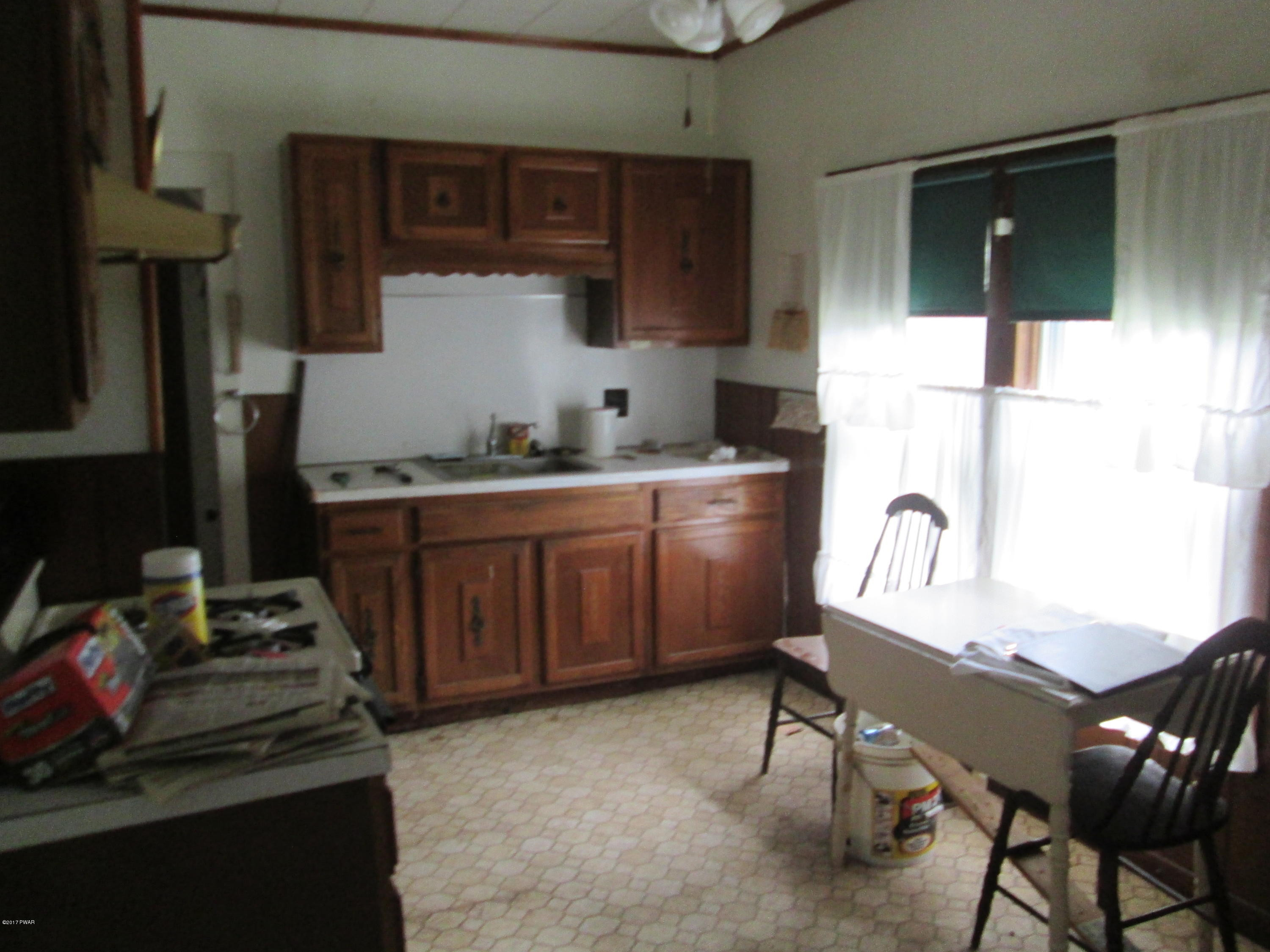 86 Beaver Hollow Road Lakewood, PA 18439 - Photo 5 of 30 a kitchen with a stove a refrigerator and wooden cabinets