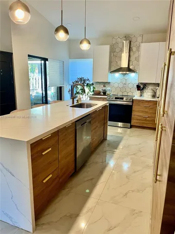 a large kitchen with kitchen island granite countertop a sink a counter space and cabinets