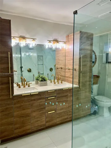 a bathroom with a double vanity sink toilet and shower