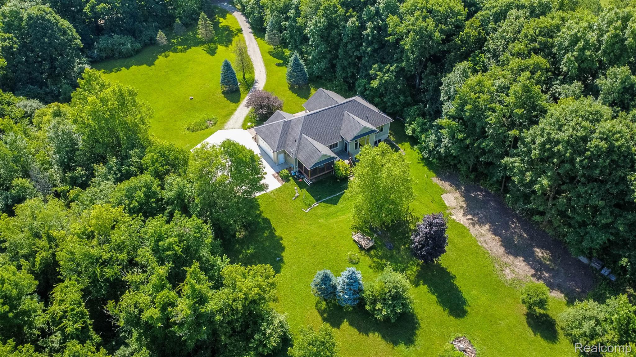 9887 Hadley Road Clarkston, MI 48348 - Photo 52 of 56 Expansive property featuring a single-story residence with a dark shingle roof, a light-colored exterior, and an attached garage