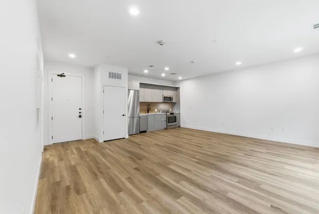 a view of an empty room with wooden floor