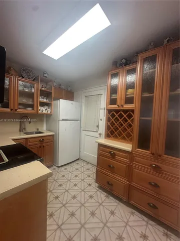 a kitchen with granite countertop a refrigerator and a stove top oven