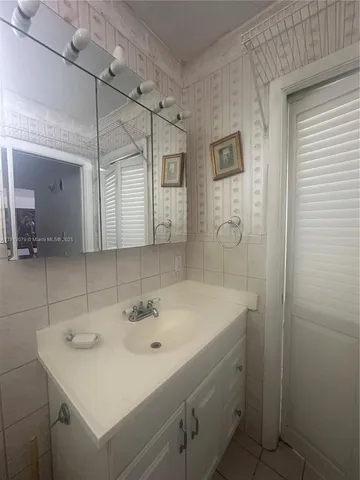 a bathroom with a sink a shower and a mirror