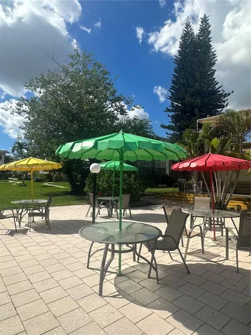 a view of a patio with a table and chairs under an umbrella