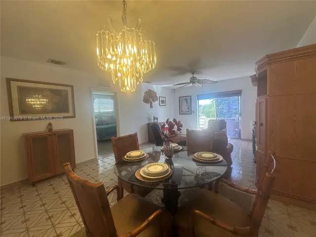 a view of a dining room with furniture and chandelier