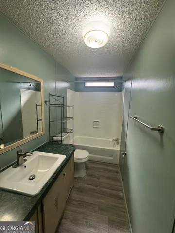 a bathroom with a sink a toilet a mirror and shower