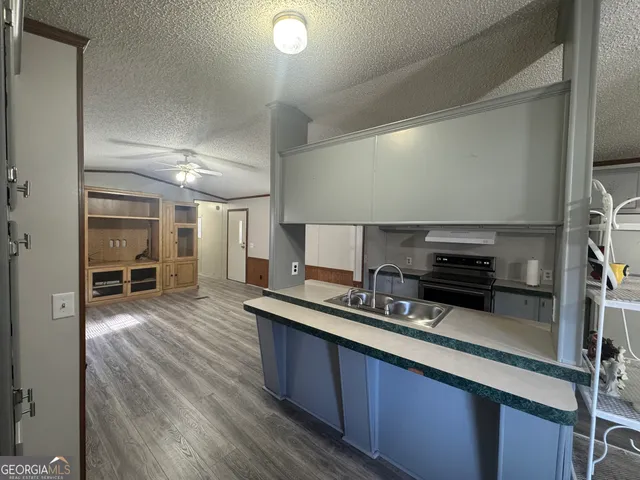 a kitchen with stainless steel appliances a sink a stove and cabinets