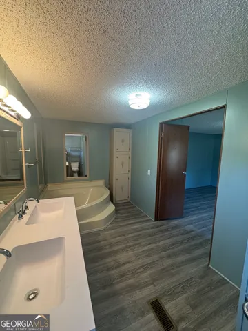 a spacious bathroom with a sink shower and a mirror