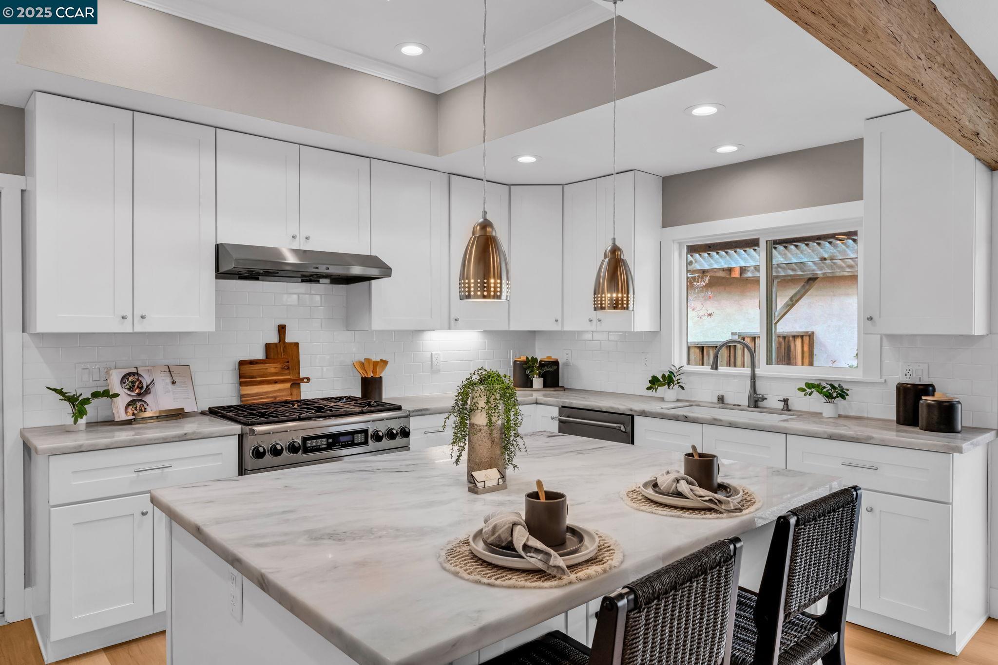 a kitchen with stainless steel appliances granite countertop a sink white cabinets and a stove