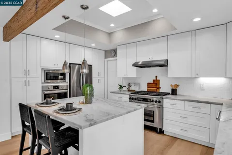 a kitchen with a sink a refrigerator and wooden floor