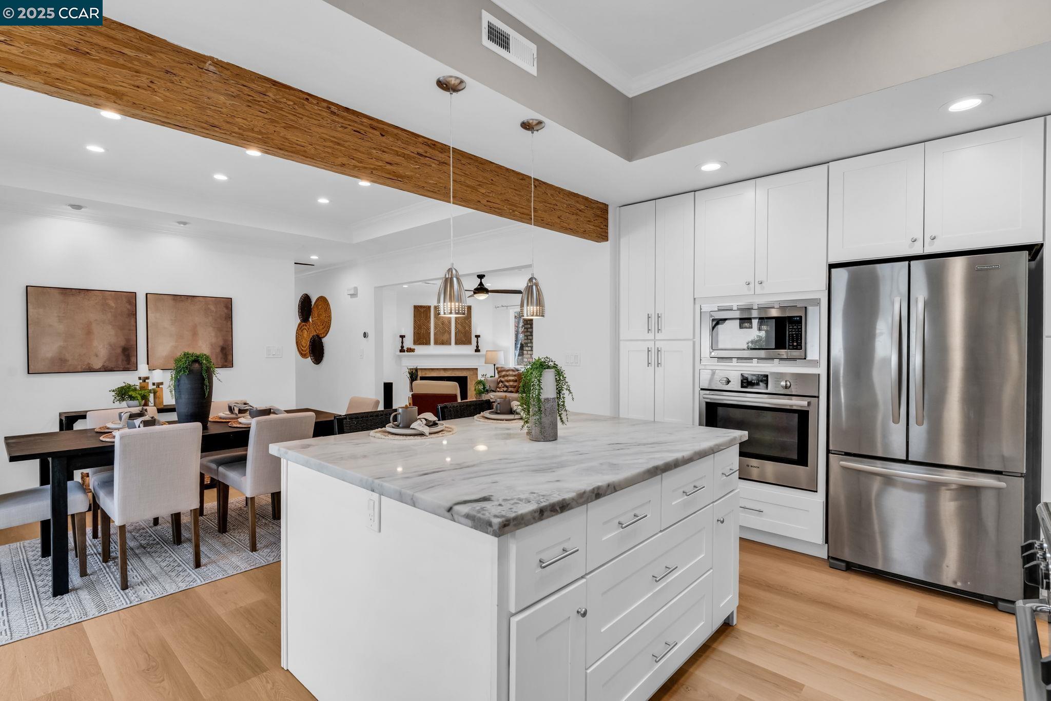 4597 Wildcat Lane Concord, CA 94521 - Photo 16 of 57 a kitchen with a center island white cabinets and stainless steel appliances