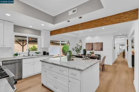 a kitchen with stainless steel appliances granite countertop white cabinets and a stove a refrigerator