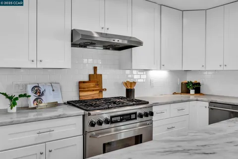 a kitchen with kitchen island granite countertop a stove and a sink