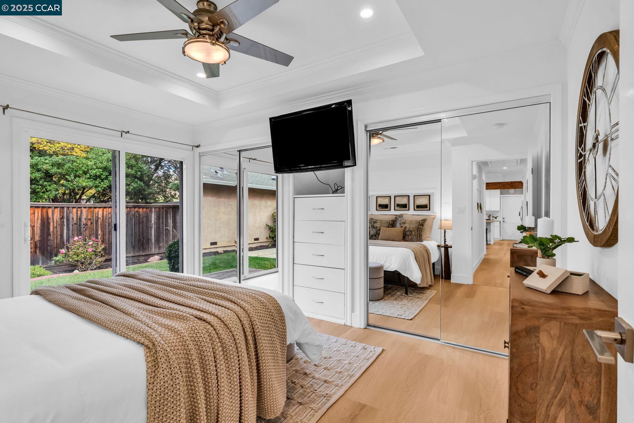 4597 Wildcat Lane Concord, CA 94521 - Photo 26 of 57 a bedroom with a bed a flat screen tv and a large window with the garden view