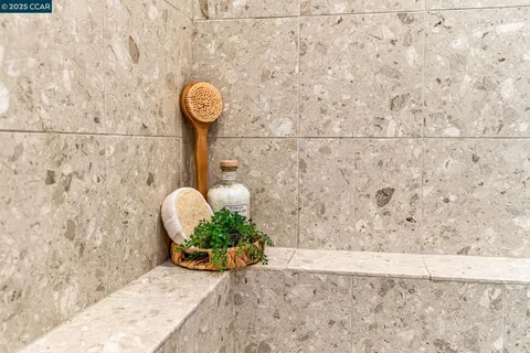 an empty room with a bathroom and a ceiling fan