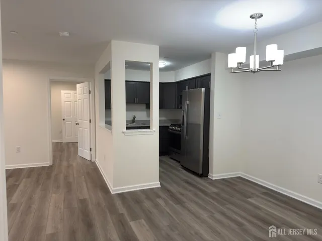 a view of a kitchen with wooden floor and refrigerator