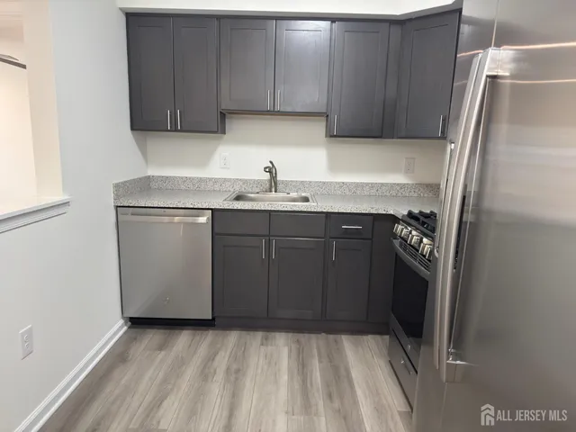 a kitchen with a sink a refrigerator and cabinets