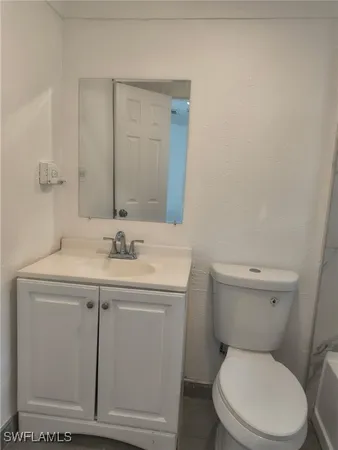 a bathroom with a toilet a sink and mirror
