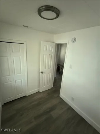 a view of a room with wooden floor and a chandelier