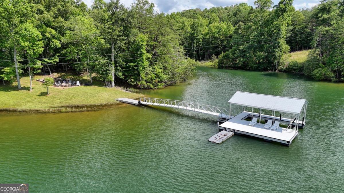 583 Fleenor Road, Unit TR 1 2 3 Blairsville, GA 30512 - Photo 87 of 99 a view of a lake with chairs and large trees