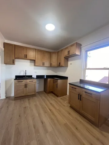 a kitchen with granite countertop a sink cabinets and stainless steel appliances