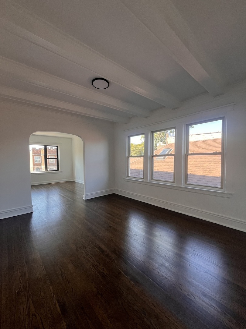 7955 South Elizabeth Street, Unit 2 Chicago, IL 60620 - Photo 6 of 10 a view of an empty room with wooden floor and a window