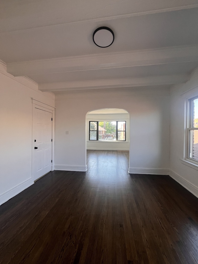 7955 South Elizabeth Street, Unit 2 Chicago, IL 60620 - Photo 7 of 10 a view of an empty room with wooden floor and a window