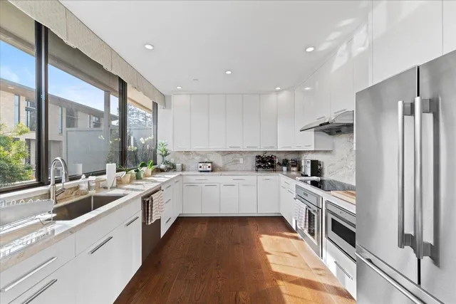 a kitchen with white cabinets and appliances