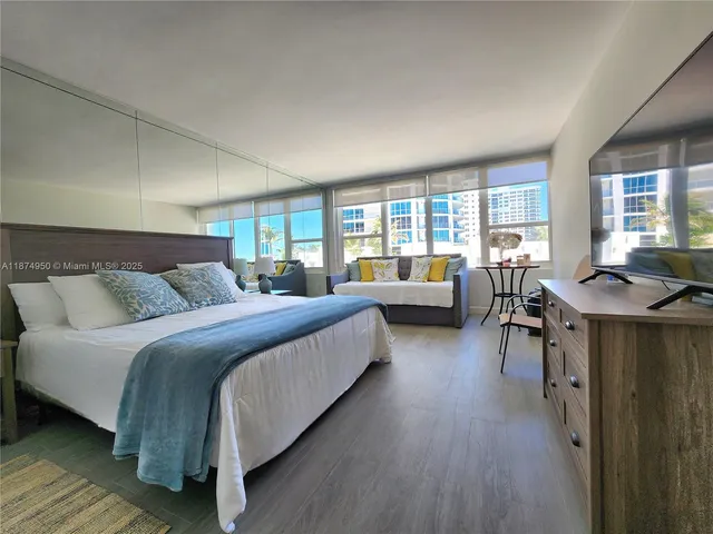 a bedroom with a large bed and a flat screen tv