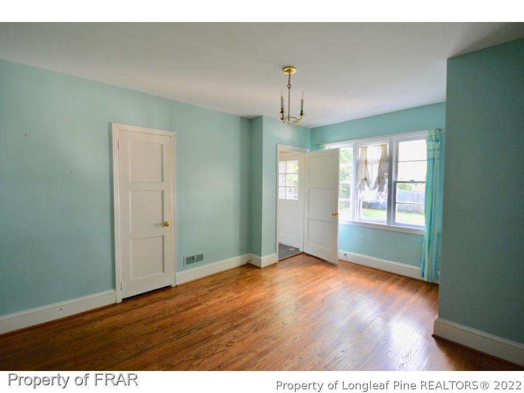 606 Rush Road Fayetteville, NC 28305 - Photo 15 of 22 a view of an empty room with window and wooden floor