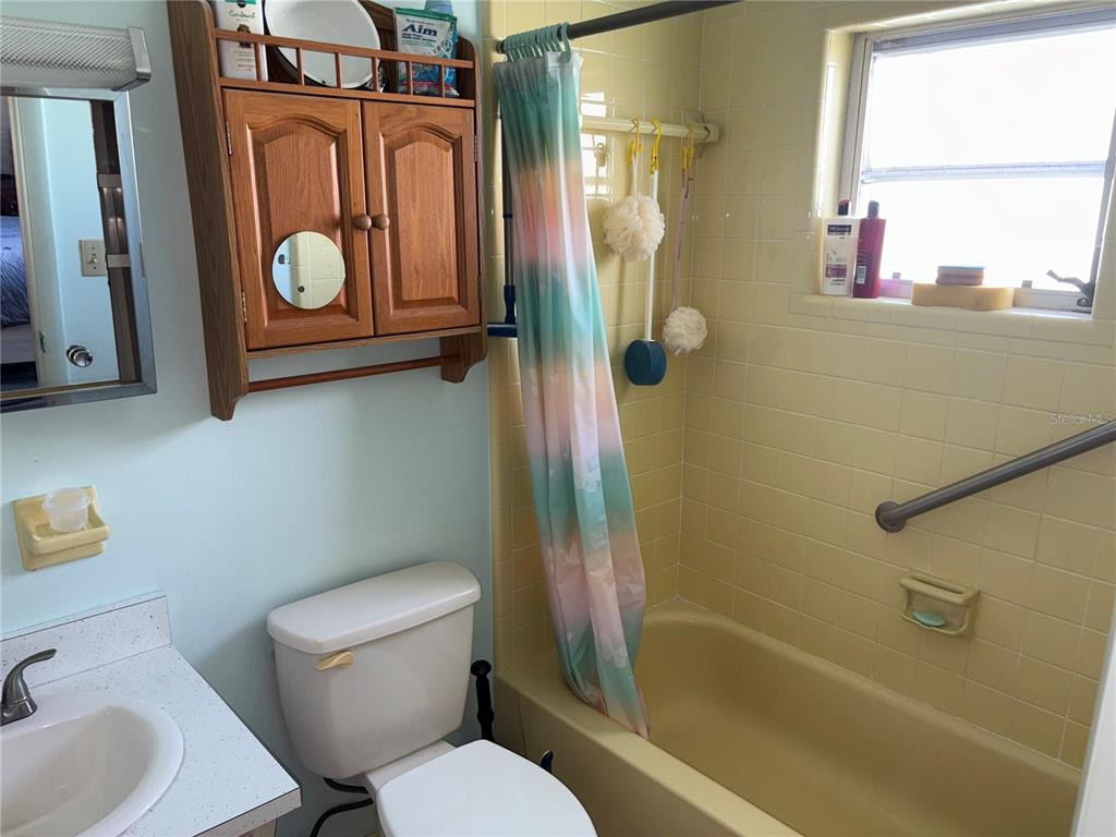 250 Rosery Road Northwest, Unit 328 Largo, FL 33770 - Photo 11 of 17 a bathroom with a toilet sink and mirror