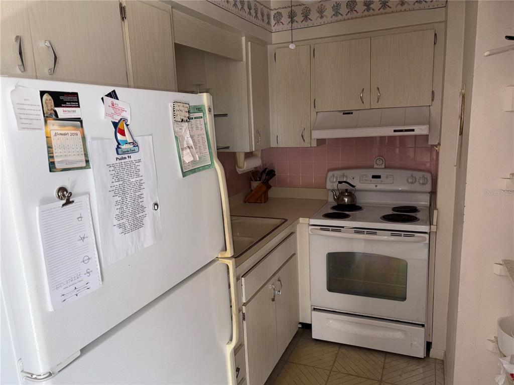 250 Rosery Road Northwest, Unit 328 Largo, FL 33770 - Photo 6 of 17 a kitchen with stainless steel appliances white cabinets and white appliances