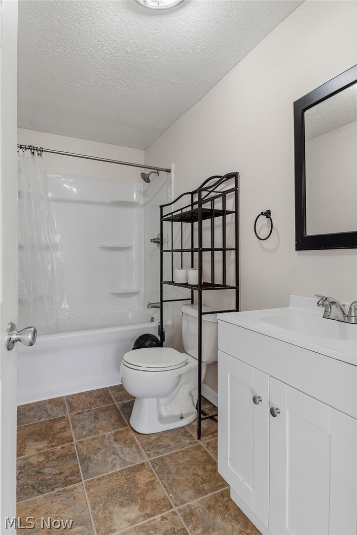 4619 Ridge Avenue Southeast Canton, OH 44707 - Photo 19 of 26 Full bathroom featuring a white vanity with integrated sink, white tub/shower combination, and tiled flooring