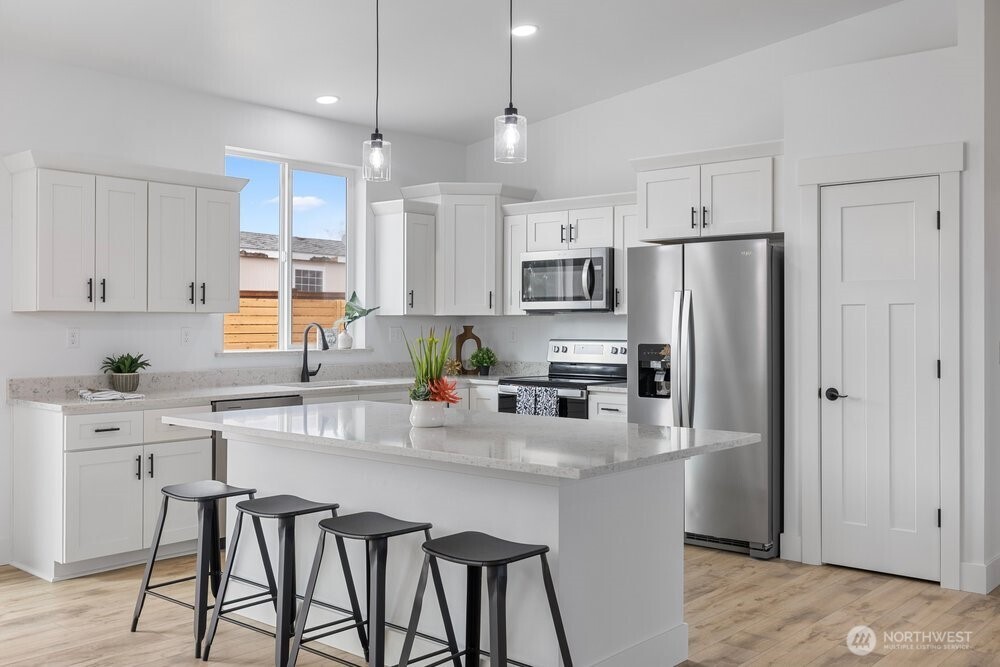 334 Spring Circle Mattawa, WA 99349 - Photo 6 of 40 a kitchen with stainless steel appliances a refrigerator a sink a stove a dining table and chairs