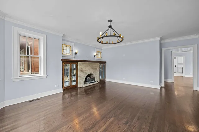 a view of empty room with wooden floor and fireplace
