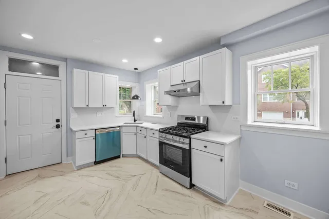 a kitchen with stainless steel appliances granite countertop a sink stove and cabinets