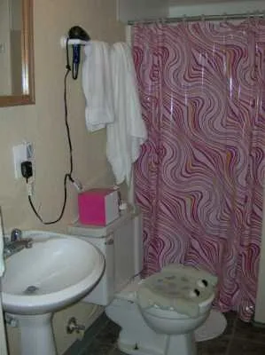 a bathroom with a sink and mirror with toilet