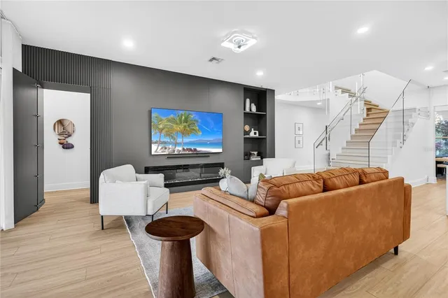 a view of a livingroom with wooden floor and a ceiling fan