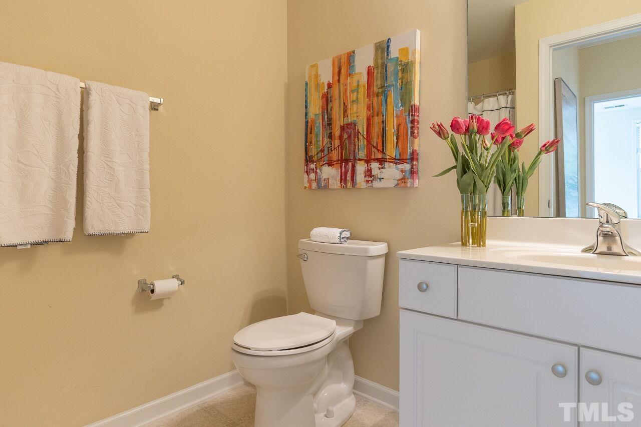 208 West Savannah Ridge Road, Unit 208 Holly Springs, NC 27540 - Photo 17 of 30 a bathroom with a toilet sink and mirror