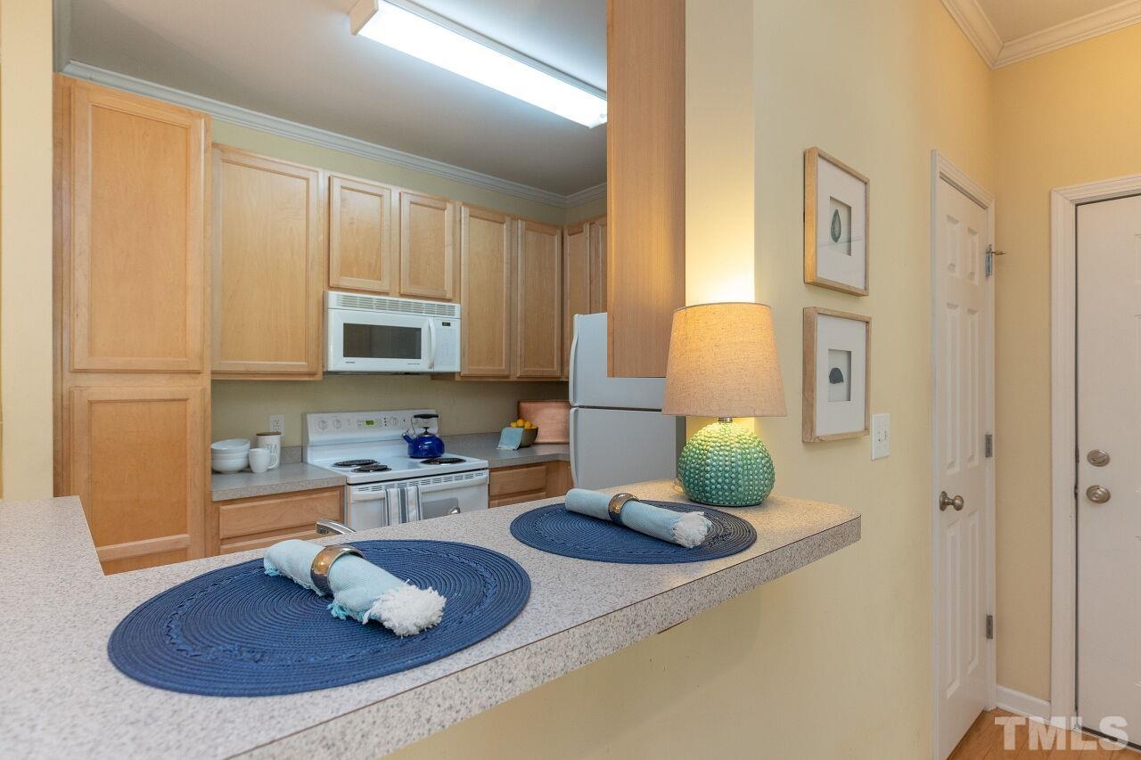 208 West Savannah Ridge Road, Unit 208 Holly Springs, NC 27540 - Photo 7 of 30 a kitchen with a sink white cabinets and a granite counter top