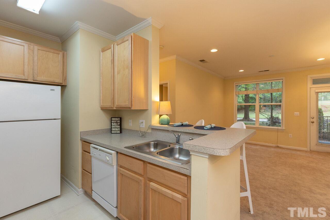 208 West Savannah Ridge Road, Unit 208 Holly Springs, NC 27540 - Photo 9 of 30 a kitchen with a sink and a refrigerator