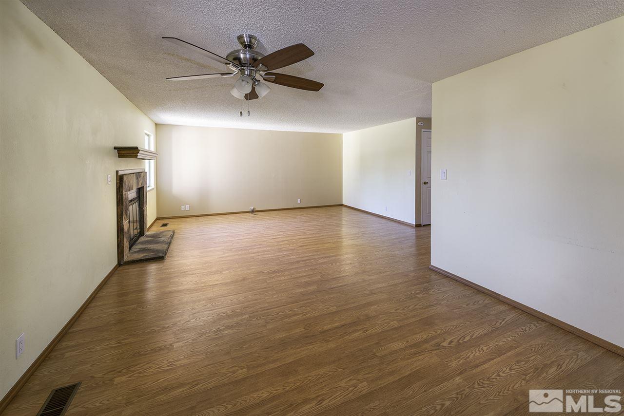 165 Ring Road Dayton, NV 89403 - Photo 5 of 19 an empty room with wooden floor a ceiling fan and a window