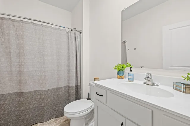 a bathroom with a sink a toilet and shower curtain
